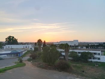 High angle view of buildings in town against sky during sunset