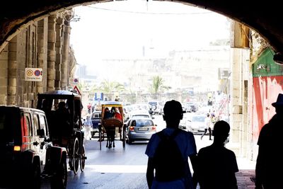 Rear view of people standing on street in city