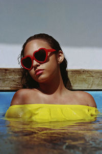 Close-up of teenage girl wearing sunglasses in swimming pool