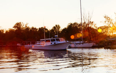 Boats sailing in river against clear sky