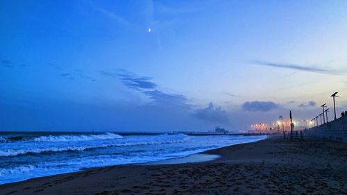 Scenic view of beach against sky at sunset