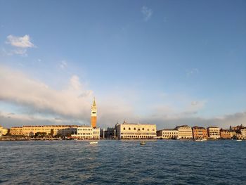 Buildings by sea against sky in city