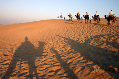 Shadow of people on sand dune