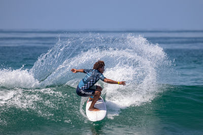 Man surfing in sea against sky