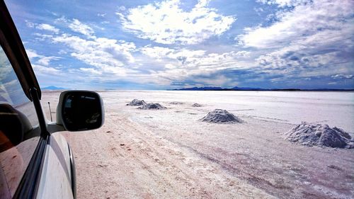 Car on beach against sky