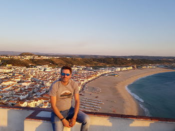 Portrait of man wearing sunglasses sitting on building terrace