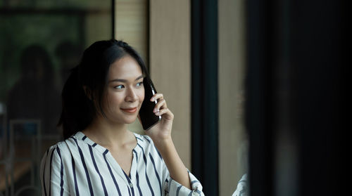 Portrait of young woman using mobile phone