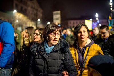 Group of people against illuminated city at night