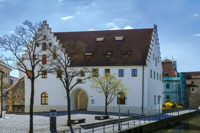 Low angle view of trees and buildings against sky