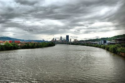 Bridge over river against cloudy sky