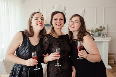 Portrait of smiling woman with friends celebrating at home