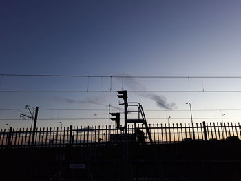 Low angle view of silhouette men against clear sky during sunset