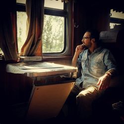 Young man looking through window