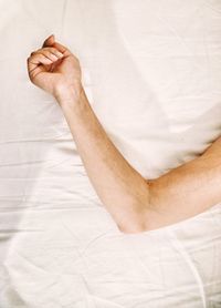 Cropped hand on bed