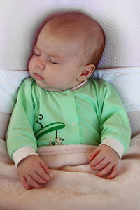 High angle view of baby sleeping on bed