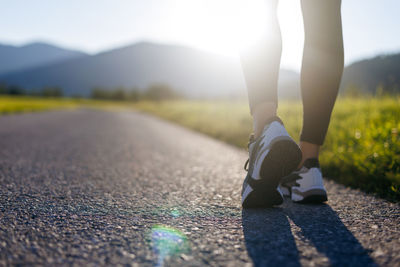 Outdoor sport concept. legs of running woman on footpath at the sunset. close up