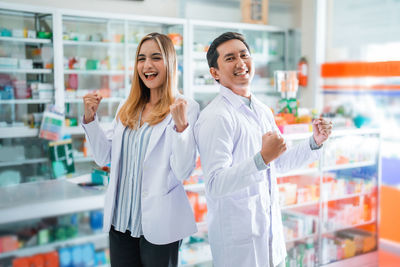 Portrait of female friends standing in laboratory