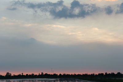 Silhouette trees on field against sky during sunset