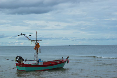 Fishing boat on sea against sky