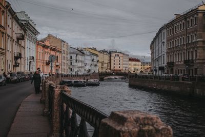 Canal amidst buildings in city against sky