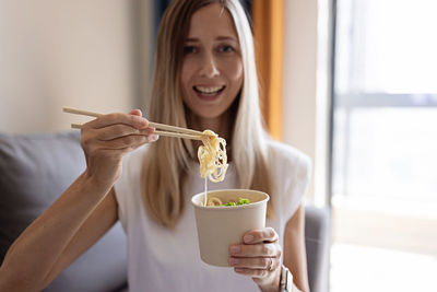 Portrait of smiling young woman holding food