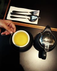 Midsection of person holding tea cup on table