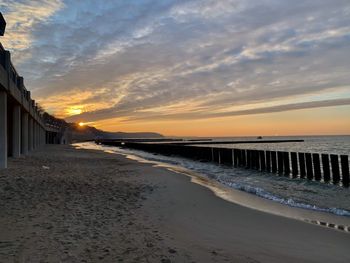 Pier over sea against sky during sunset