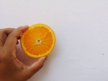 Cropped image of hand holding orange