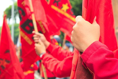 Close-up of human hands holding red flags