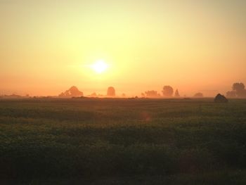 Scenic view of field against clear sky during sunset