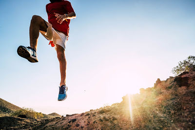 Low angle view of man jumping against sky