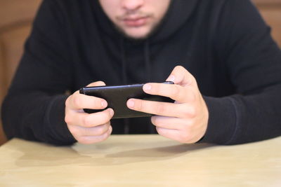 Midsection of man using mobile phone