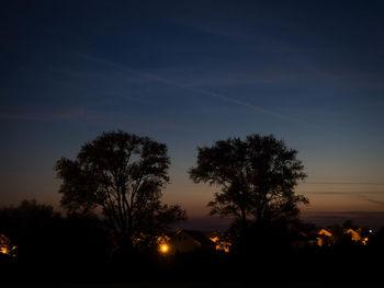 Silhouette trees against sky at night
