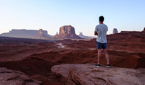 Rear view of man standing on rock