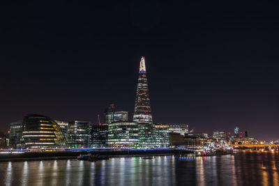 Illuminated the shard by thames river against clear sky at night
