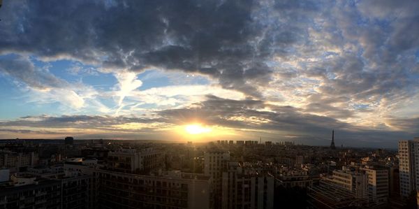 Cityscape against cloudy sky during sunset