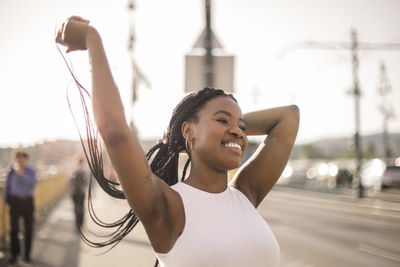 Woman tying dreads at street