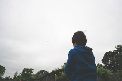 Low angle view of boy flying kite