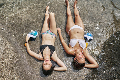 Two girls lying on the seashore sunbathing. holiday concept and lifestyle.