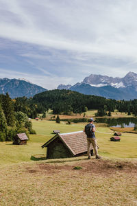 People on field by houses against sky