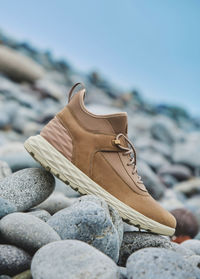 A pair of brown leather waterproof trekking boots on a sea coast. hiking concept.