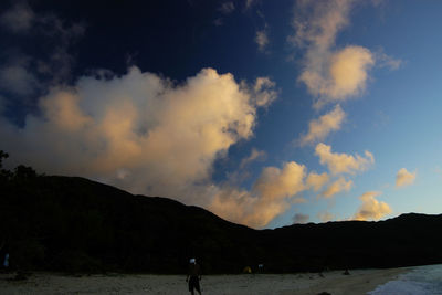 Silhouette people standing on land against sky during sunset