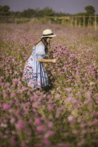 Woman standing in front of flowering plants on field