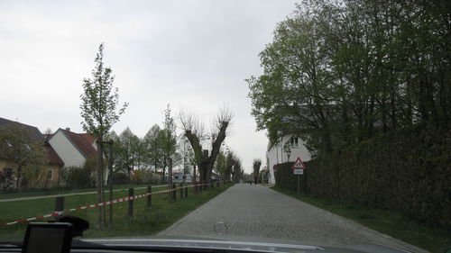 Road amidst trees against sky