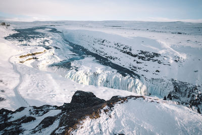 Scenic view of  frozen waterfall against sky during winter