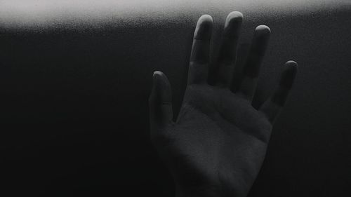 Close-up of human hand against black background