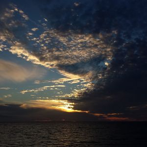 Scenic view of sea against dramatic sky during sunset