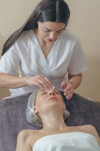 Woman cleaning customer face