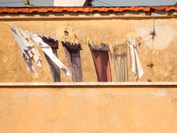 Low angle view of laundry hanging on clothesline at terrace