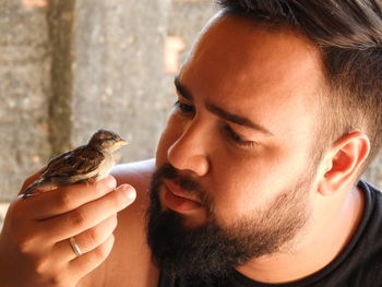 Close-up of young woman holding bird